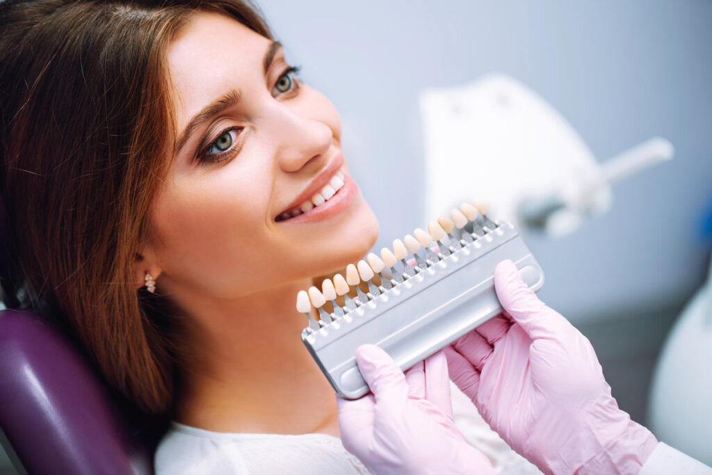 Tooth whitening, perfect white teeth close up with shade guide bleach color. Healthy teeth and medicine concept.
